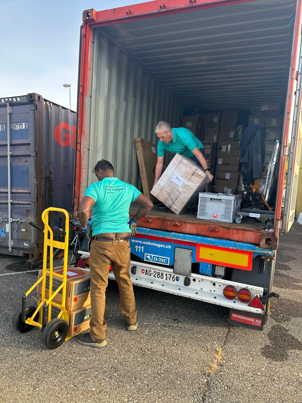 Thaitransport-Mitarbeiter beladen einen Container für den Transport nach Thailand